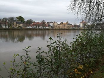 Scenic view of lake by houses in town against sky