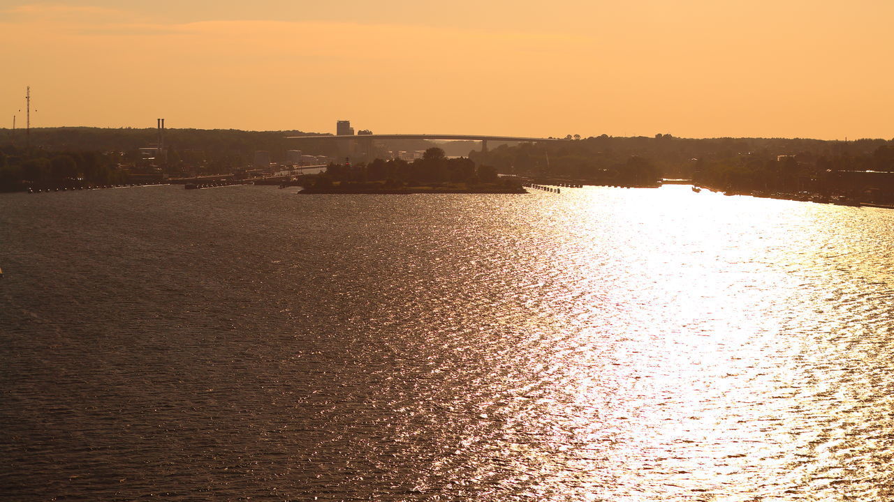 SCENIC VIEW OF RIVER AGAINST ORANGE SKY DURING SUNSET