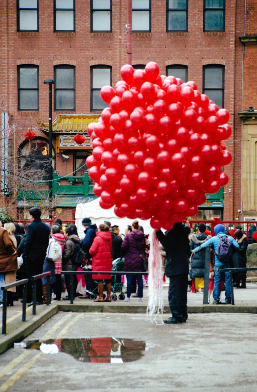 red, building exterior, architecture, balloon, built structure, full length, celebration, city, city life, outdoors, women, men, day, people, travel destinations, adult, large group of people, standing, adults only, togetherness, crowd, only men