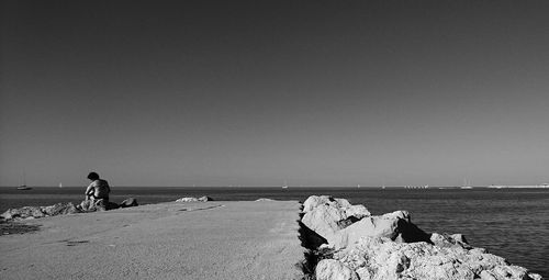 People on beach against clear sky