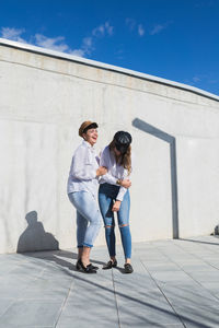 Full length of friends standing on wall