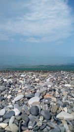 Stones on beach against sky