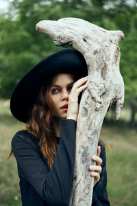 Portrait of young woman wearing hat standing outdoors