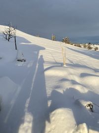 Snow covered land against sky