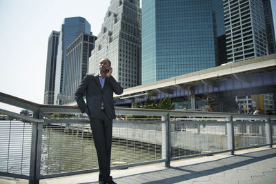 Low angle view of businessman standing against buildings