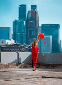 Rear view of woman standing against red water