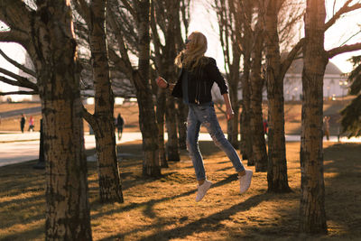 Woman jumping amidst trees