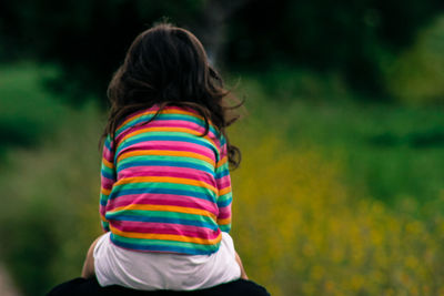 Rear view of woman standing by railing