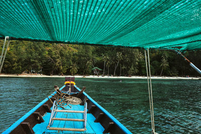 Rear view of man sitting on boat sailing in sea