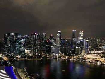 Illuminated buildings in city against sky at night
