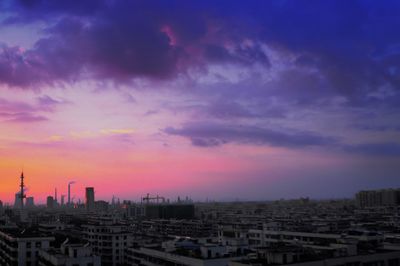 View of cityscape against cloudy sky