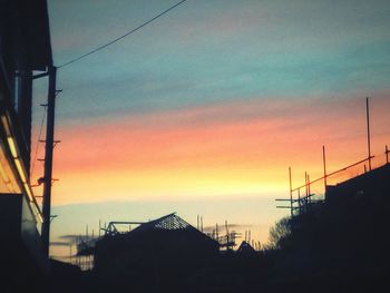 Silhouette buildings against sky during sunset