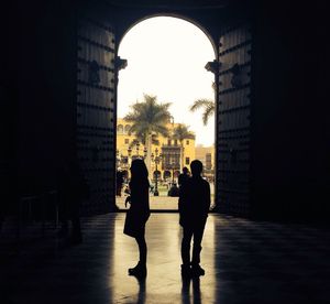 Silhouette people walking in corridor of building