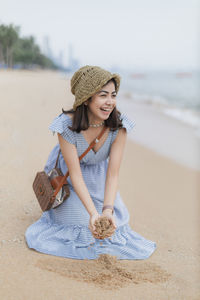 Full length of smiling young woman on beach