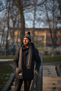 Young man in warm clothing moving down on steps at park