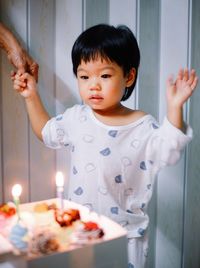 Portrait of cute girl playing with birthday cake