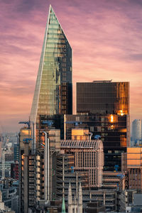 Modern buildings against sky during sunset