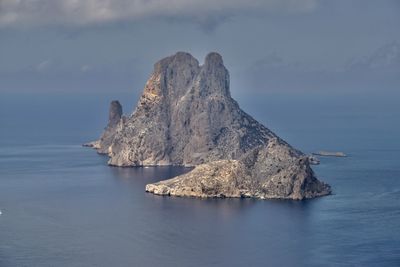 Rock formations by sea against sky