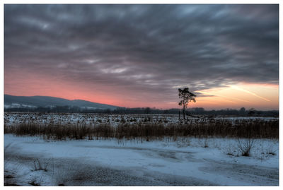 Scenic view of snow field against sky during sunset