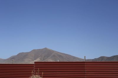 Scenic view of mountains against clear blue sky