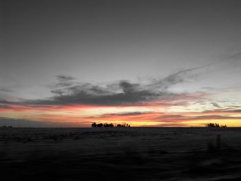 Snow covered landscape against sky at sunrise