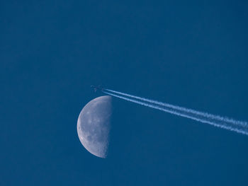 Low angle view of vapor trail against blue sky
