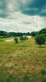 Scenic view of field against cloudy sky