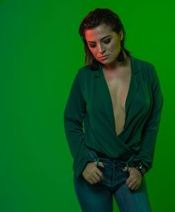 Female model standing against green background