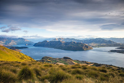 Scenic view of lake by mountains against sky