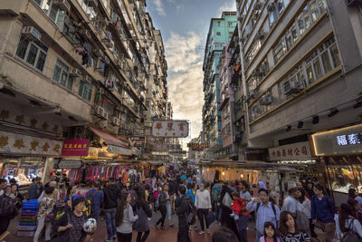 People walking on street amidst buildings in city