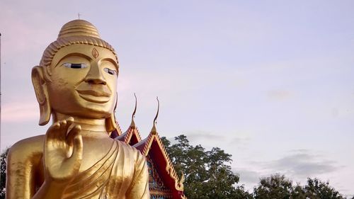 Low angle view of statue against temple against sky