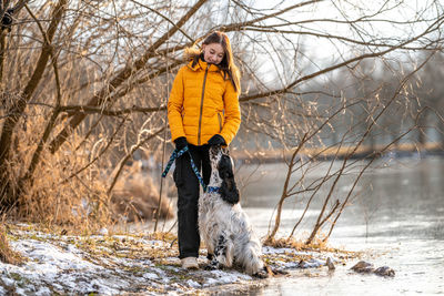 Full length of woman standing on snow covered field