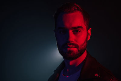 Portrait of young man against black background