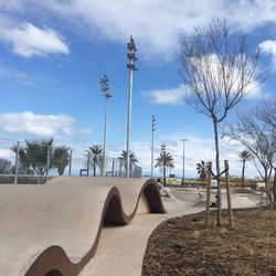 Bare trees in park against sky