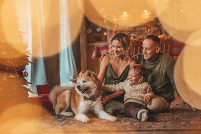 Candid authentic happy family during wintertime together enjoying holidays with dog at xmas