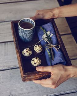 High angle view of hand holding coffee cup on table