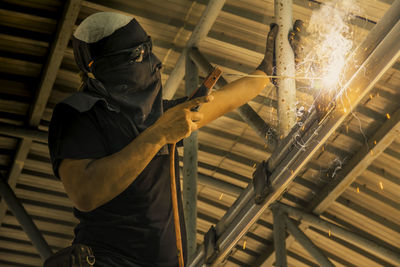Low angle view of man welding in factory