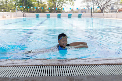 Smiling boy swimming in pool