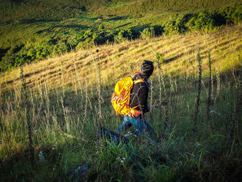 Side view of man hiking on grass