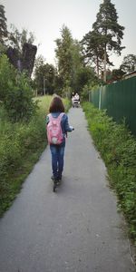 Rear view of women walking on footpath