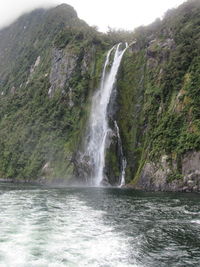 Scenic view of waterfall against sky