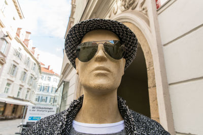 Low angle portrait of man wearing sunglasses against building