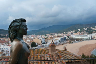 View of cityscape against cloudy sky
