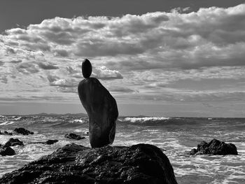 Rear view of man looking at sea against sky