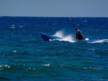 Man surfing in sea against clear sky