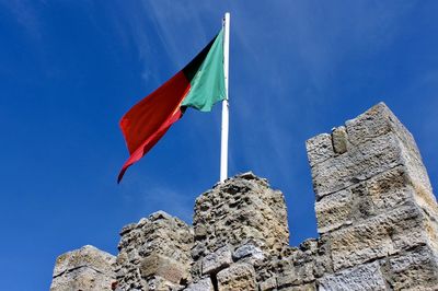 Low angle view of portugal flag against blue sky