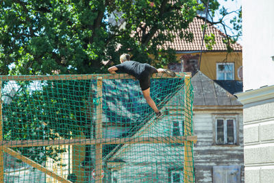 Full length of man jumping outside house
