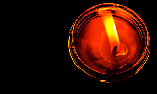 Close-up of illuminated lighting equipment against black background