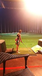 Rear view of woman sitting on bench