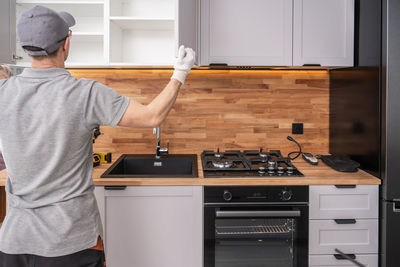 Rear view of man working in kitchen